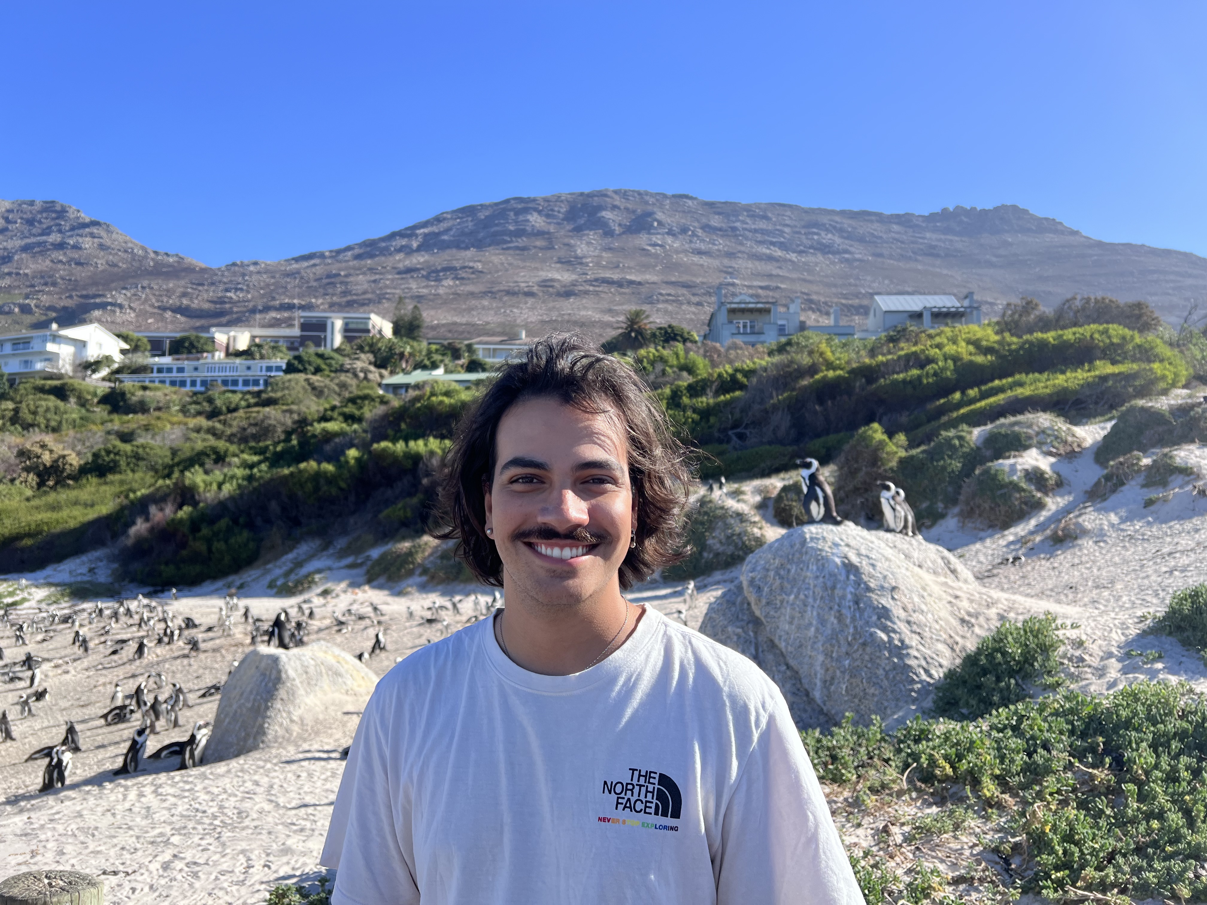 Picture of Dev standing in front of penguins in South Africa